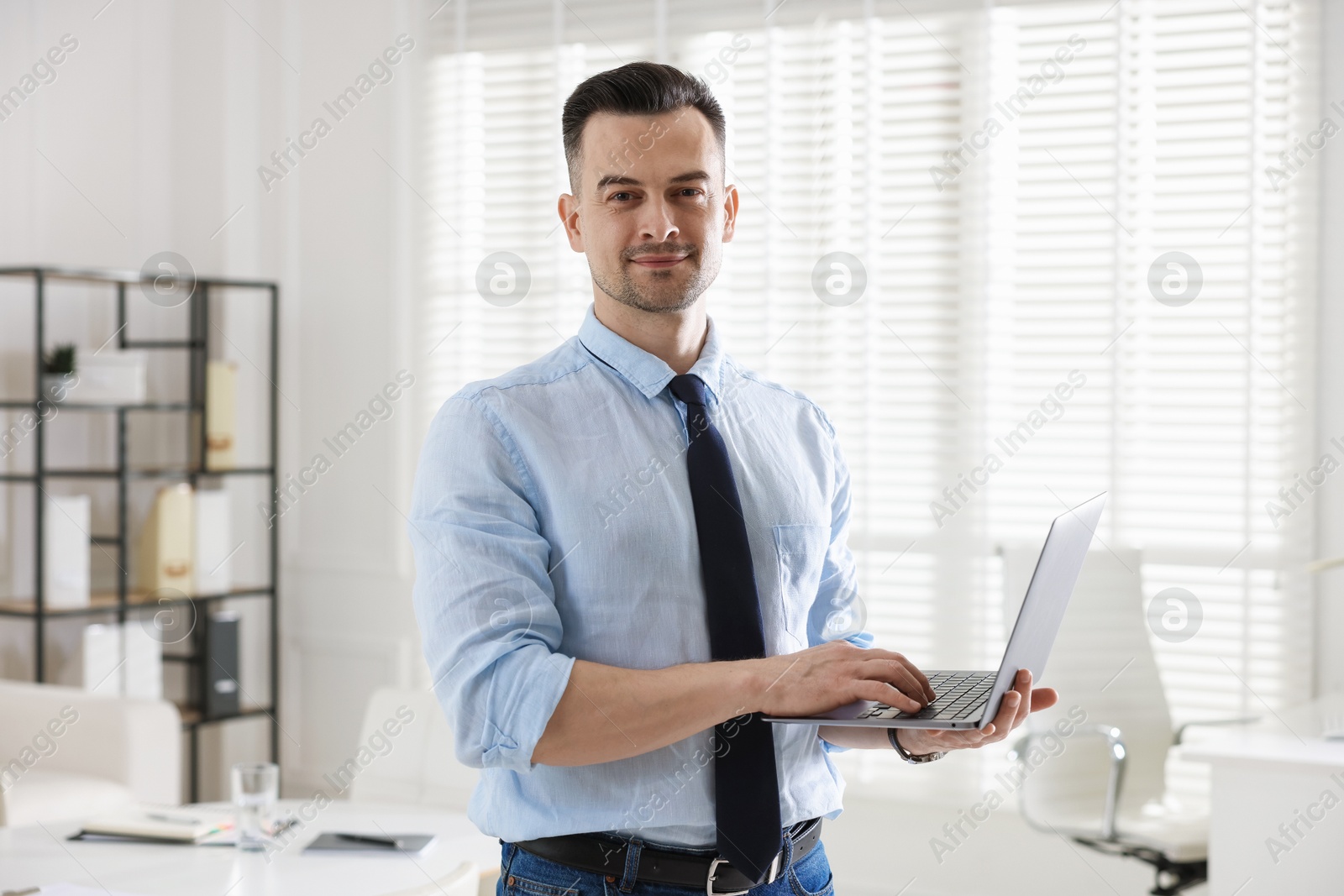 Marketing. Smiling man with laptop in office Photo of Marketing. Smiling man with laptop in office