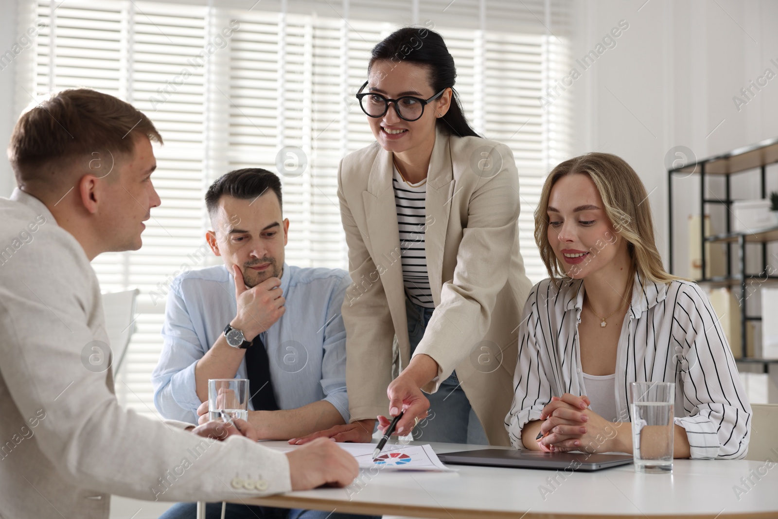 Marketing. Team of businesspeople working together at desk in office Photo of Marketing. Team of businesspeople working together at desk in office