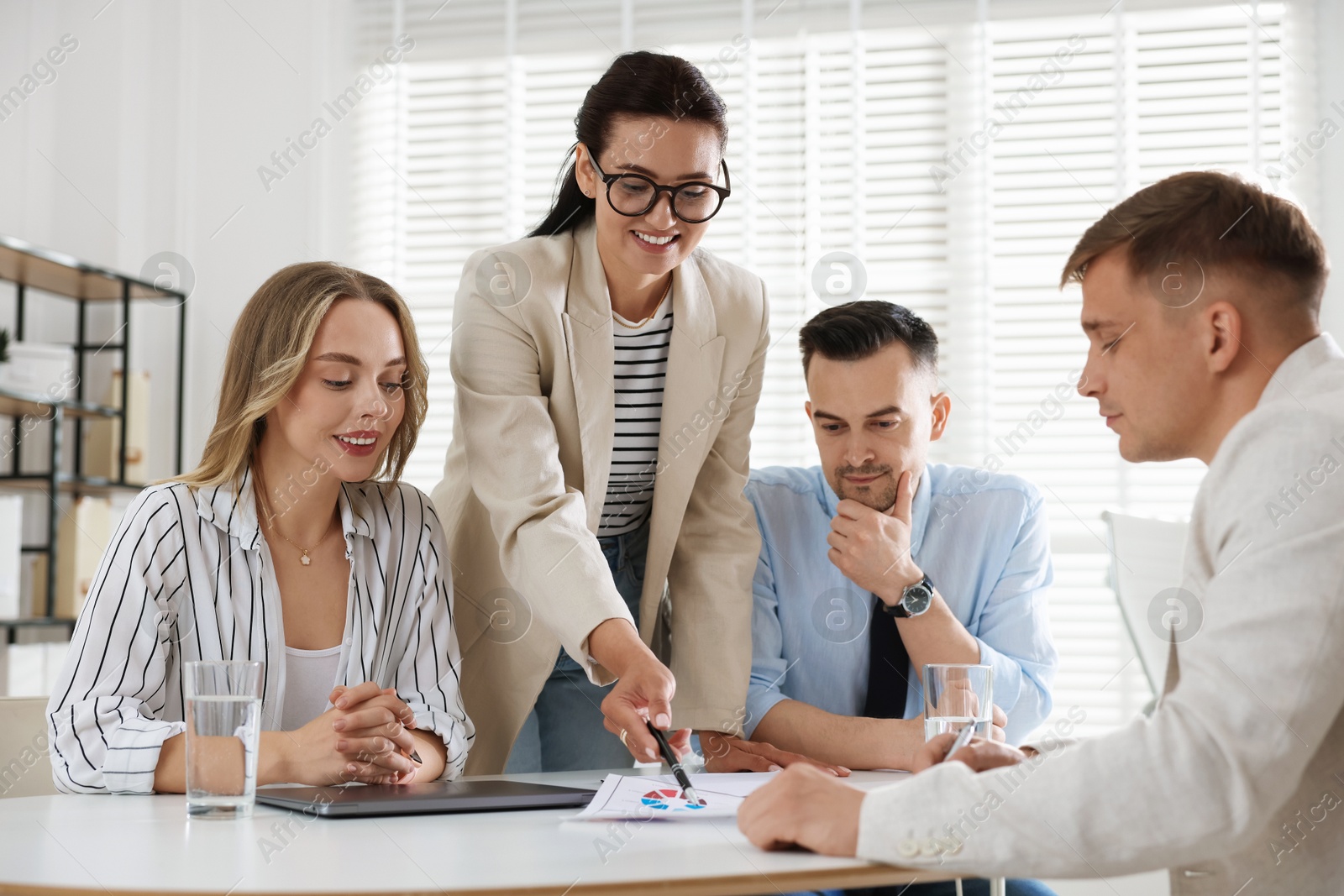 Marketing. Team of businesspeople working together at desk in office Photo of Marketing. Team of businesspeople working together at desk in office