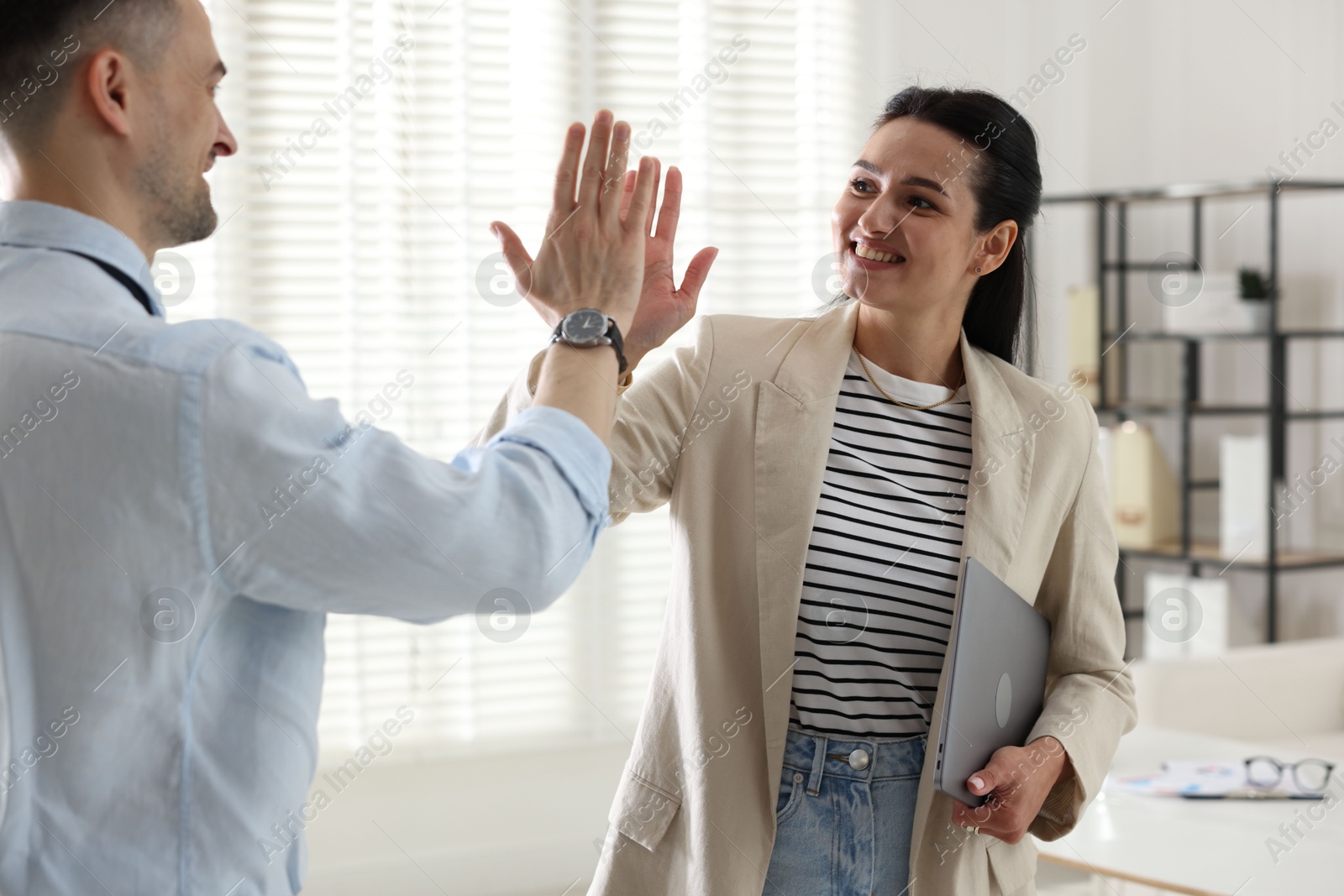 Marketing. Colleagues giving high five in office Photo of Marketing. Colleagues giving high five in office