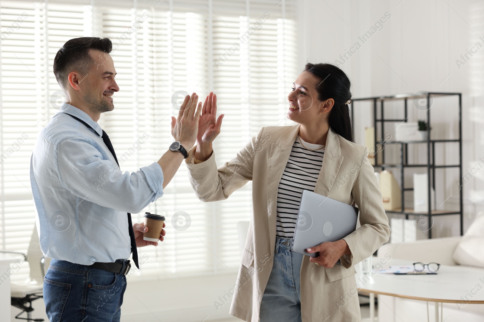 Marketing. Colleagues giving high five in office Photo of Marketing. Colleagues giving high five in office