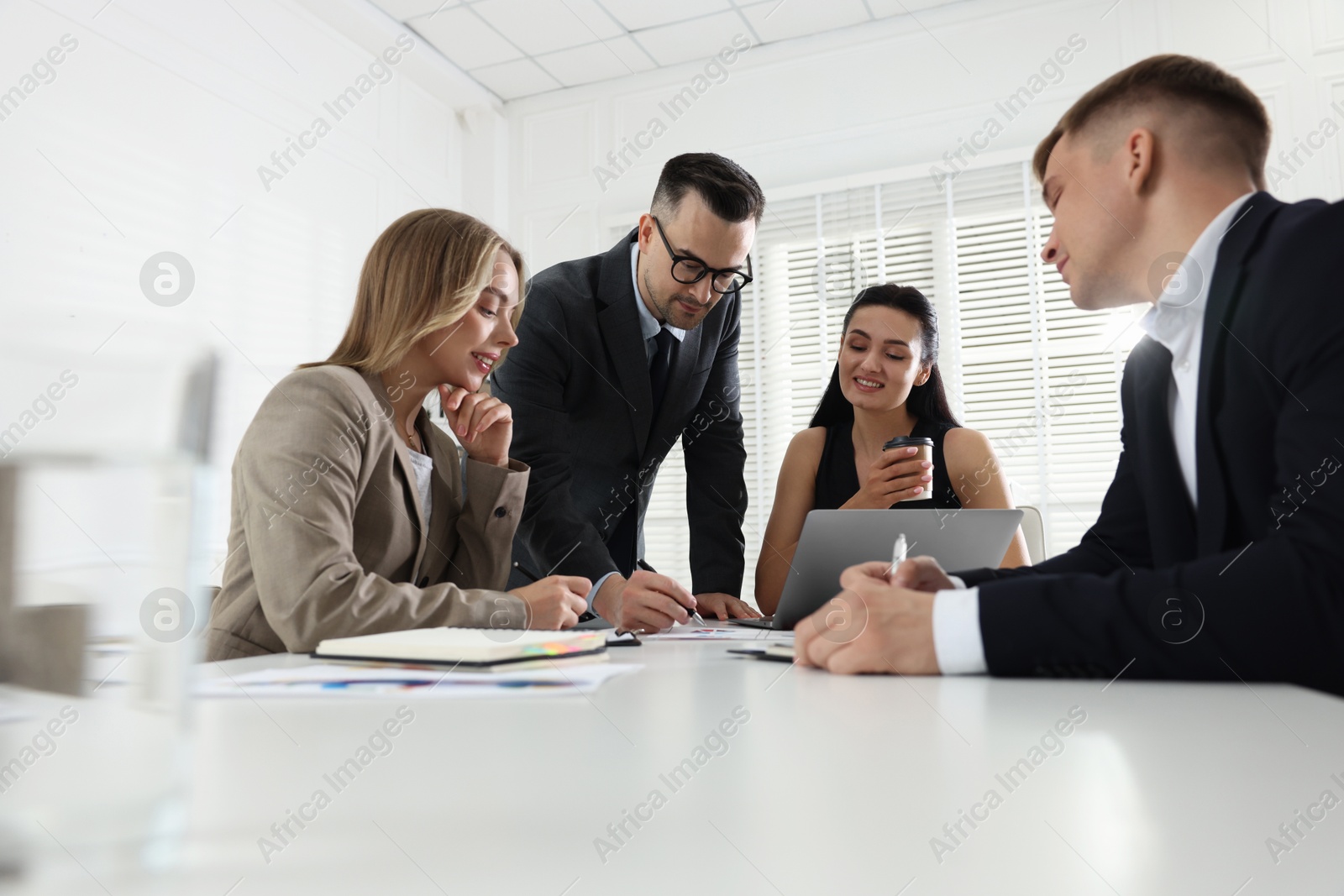 Marketing. Team of businesspeople working together at desk in office Photo of Marketing. Team of businesspeople working together at desk in office
