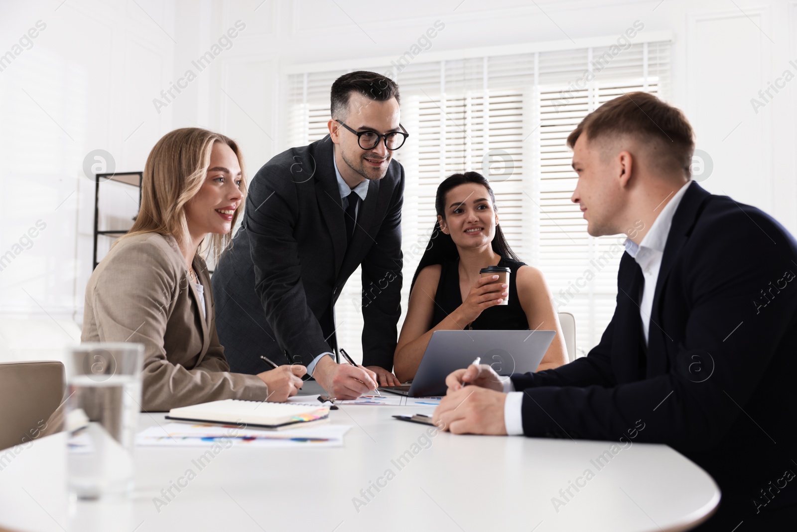 Marketing. Team of businesspeople working together at desk in office Photo of Marketing. Team of businesspeople working together at desk in office