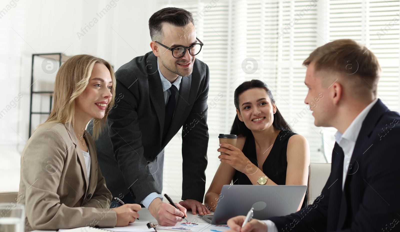Marketing. Team of businesspeople working together at desk in office Photo of Marketing. Team of businesspeople working together at desk in office