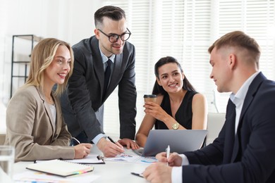 Photo of Marketing. Team of businesspeople working together at desk in office