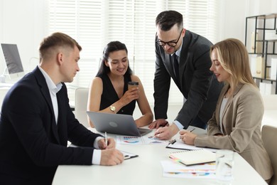 Photo of Marketing. Team of businesspeople working together at desk in office