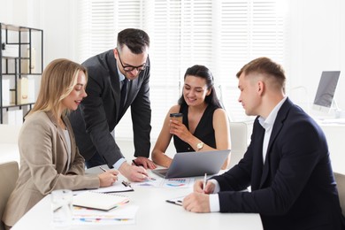 Photo of Marketing. Team of businesspeople working together at desk in office