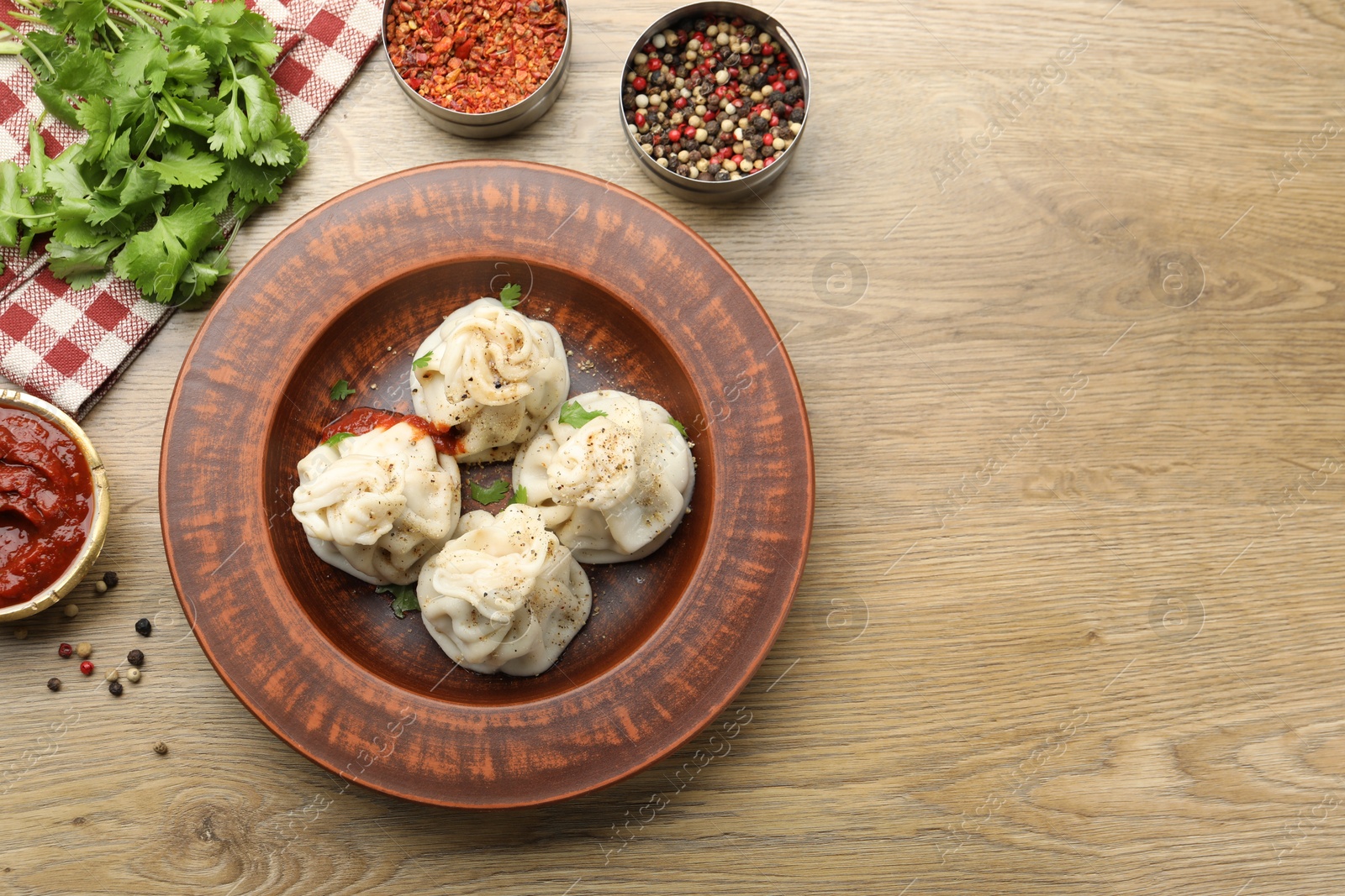 Tasty khinkali with sauce and spices on wooden table, flat lay. Space for text Photo of Tasty khinkali with sauce and spices on wooden table, flat lay. Space for text