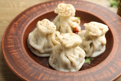 Photo of Tasty khinkali with spices on wooden table, closeup
