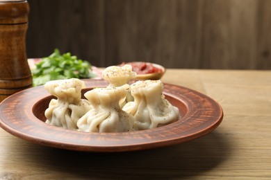 Photo of Tasty khinkali with spices on wooden table