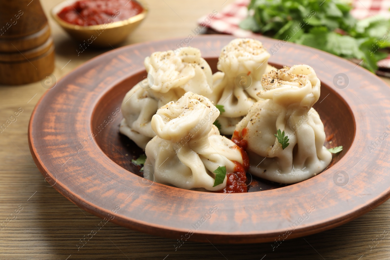 Tasty khinkali with spices on wooden table, closeup Photo of Tasty khinkali with spices on wooden table, closeup