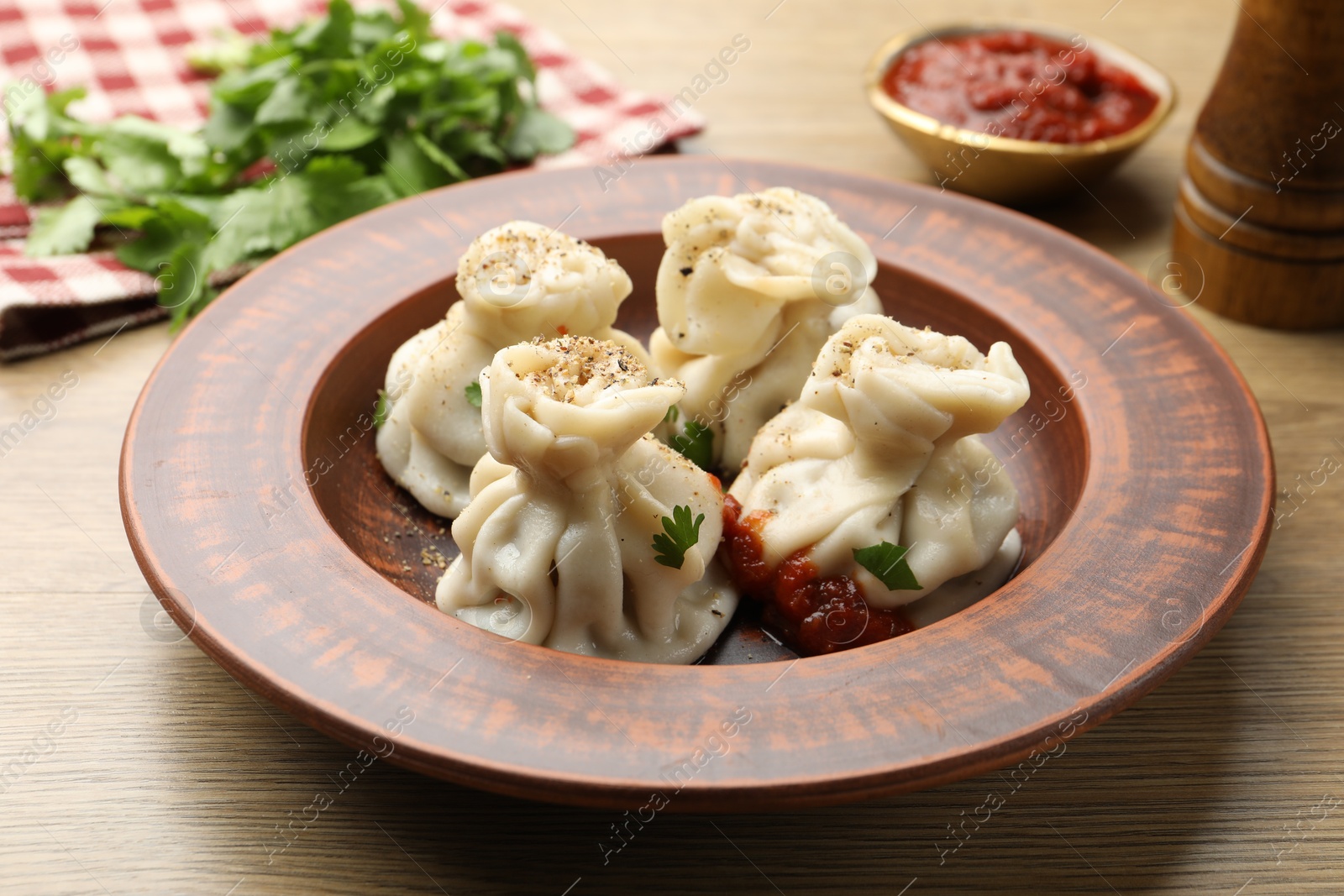 Tasty khinkali with spices on wooden table Photo of Tasty khinkali with spices on wooden table