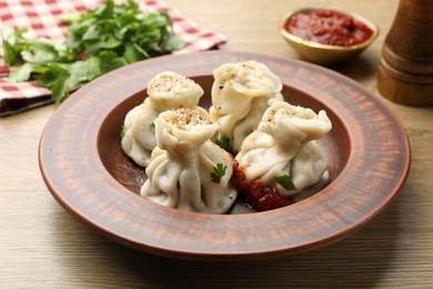 Photo of Tasty khinkali with spices on wooden table