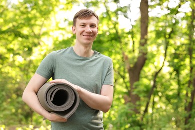 Photo of Young man with yoga mat in park