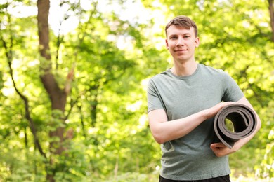 Photo of Young man with yoga mat in park