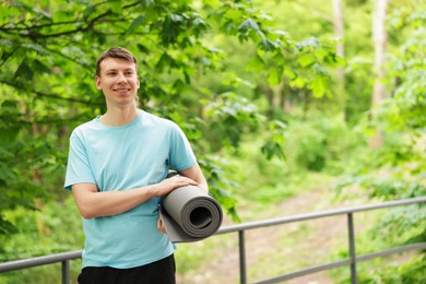 Photo of Young man with yoga mat in park