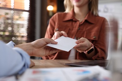 Photo of Money bonus. Employee receiving envelope from boss in office, closeup