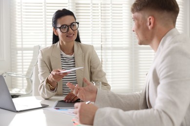 Photo of Money bonus. Employee receiving envelope from boss in office