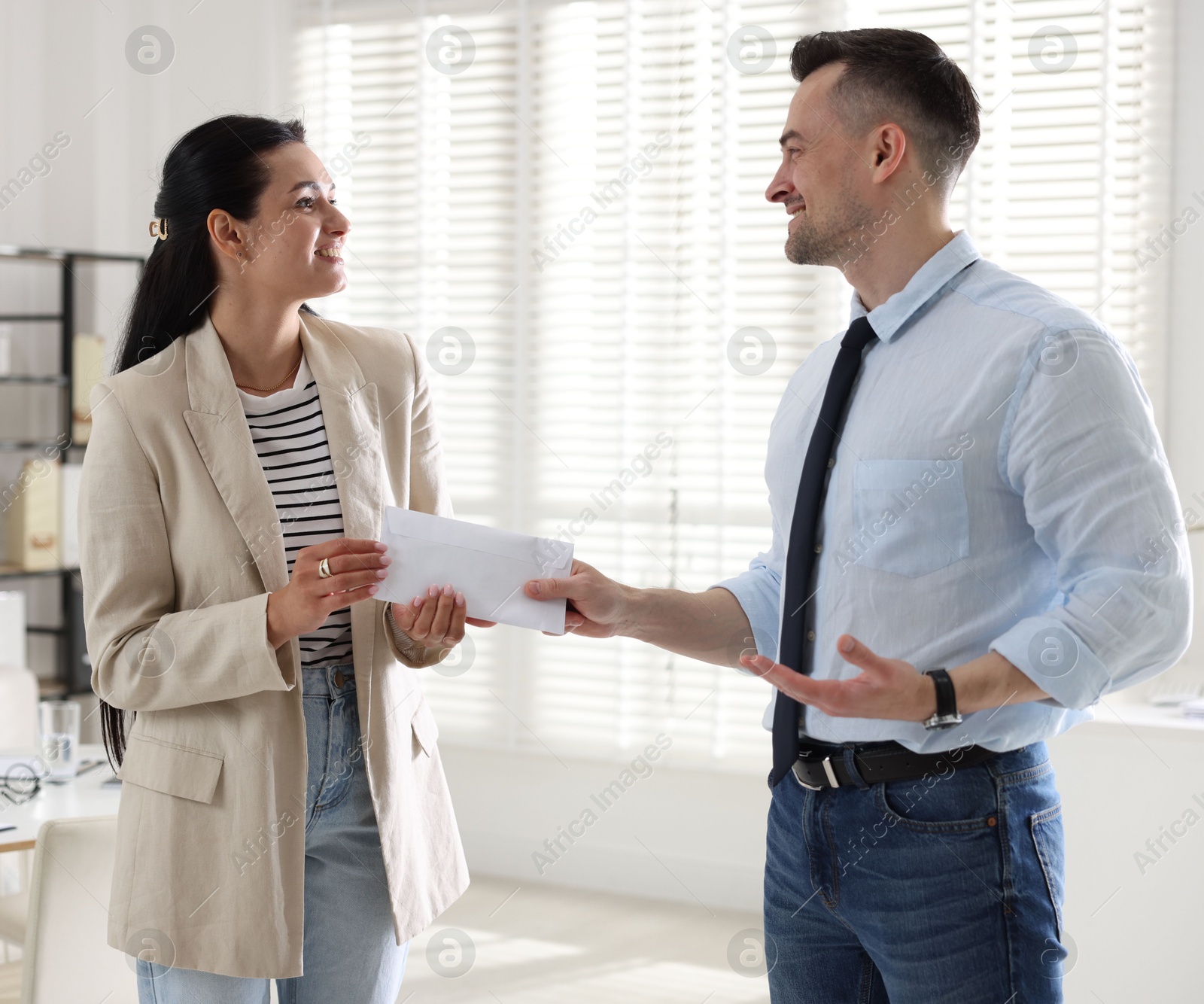 Money bonus. Boss giving envelope to employee in office Photo of Money bonus. Boss giving envelope to employee in office