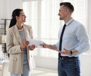 Photo of Money bonus. Boss giving envelope to employee in office