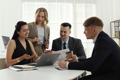 Photo of Marketing. Team of businesspeople working together at desk in office