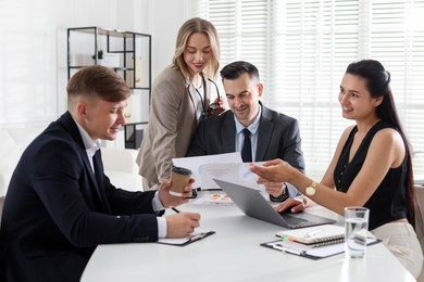 Photo of Marketing. Team of businesspeople working together at desk in office