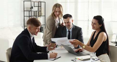 Photo of Marketing. Team of businesspeople working together at desk in office