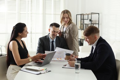 Photo of Marketing. Team of businesspeople working together at desk in office