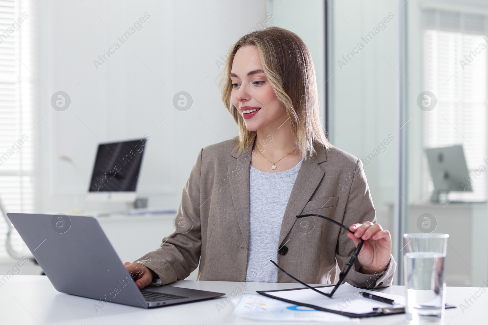 Marketing. Woman working with laptop at desk in office Photo of Marketing. Woman working with laptop at desk in office