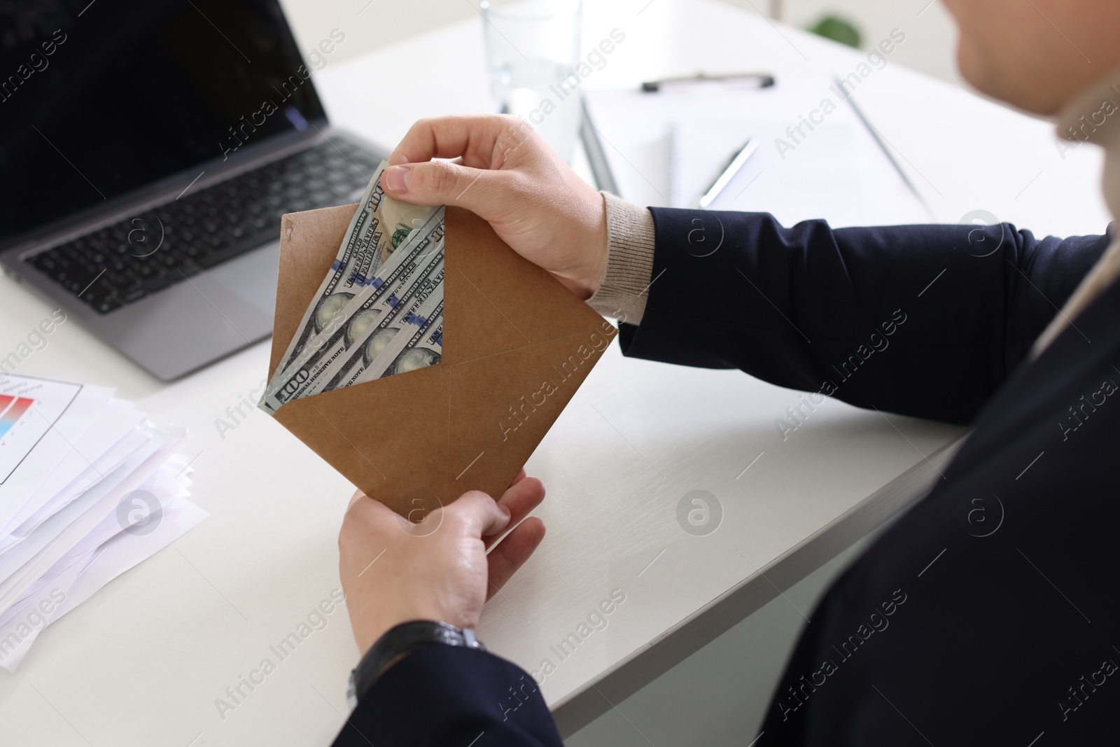 Bonus. Man holding envelope with money at desk in office, closeup Photo of Bonus. Man holding envelope with money at desk in office, closeup