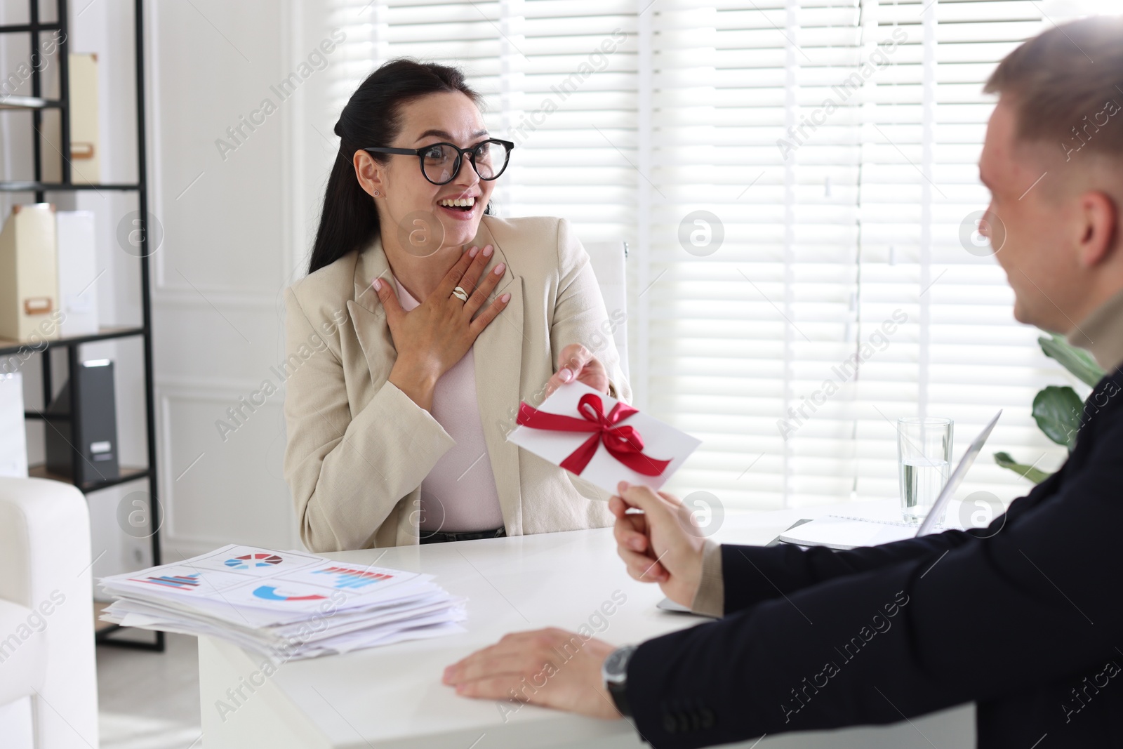 Money bonus. Employee receiving envelope with bow from boss in office Photo of Money bonus. Employee receiving envelope with bow from boss in office