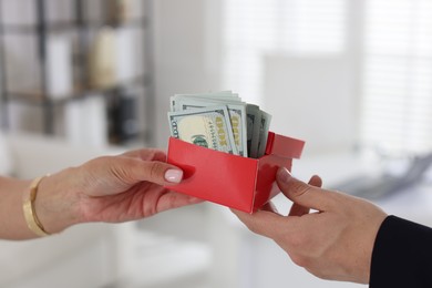 Photo of Bonus. Boss giving box with money to employee in office, closeup