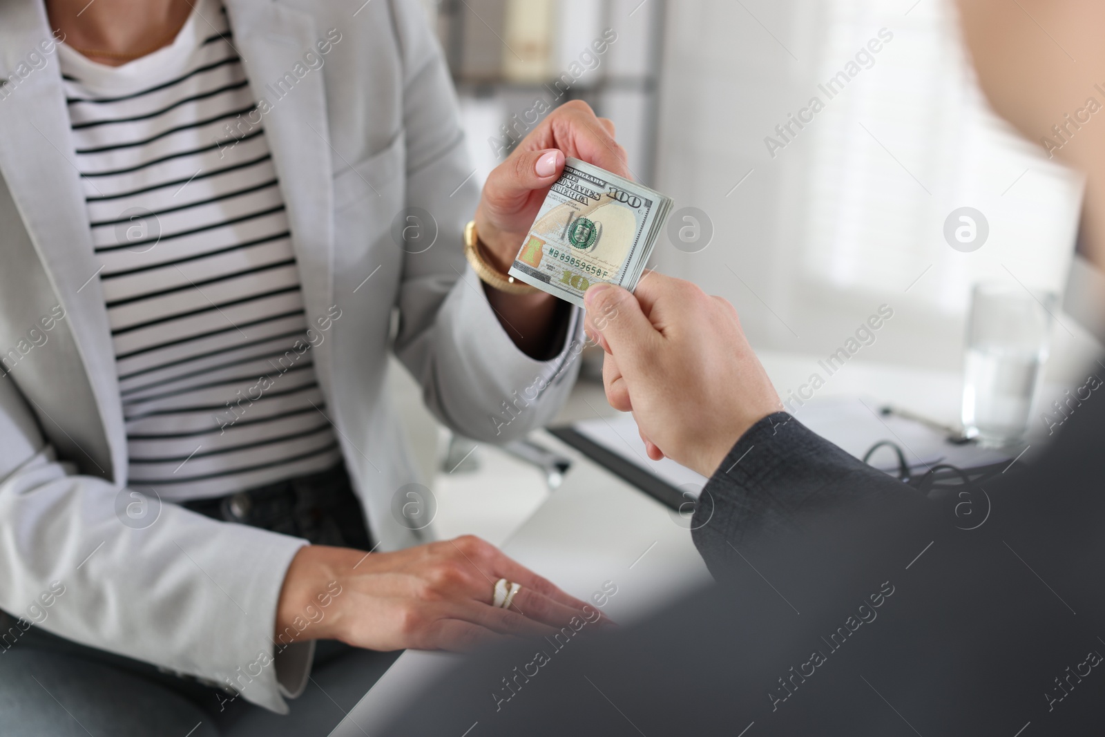 Bonus. Boss giving money to employee in office, closeup Photo of Bonus. Boss giving money to employee in office, closeup