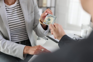 Photo of Bonus. Boss giving money to employee in office, closeup