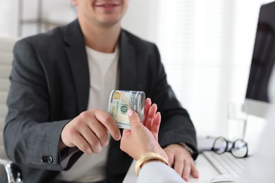 Photo of Bonus. Boss giving money to employee in office, closeup
