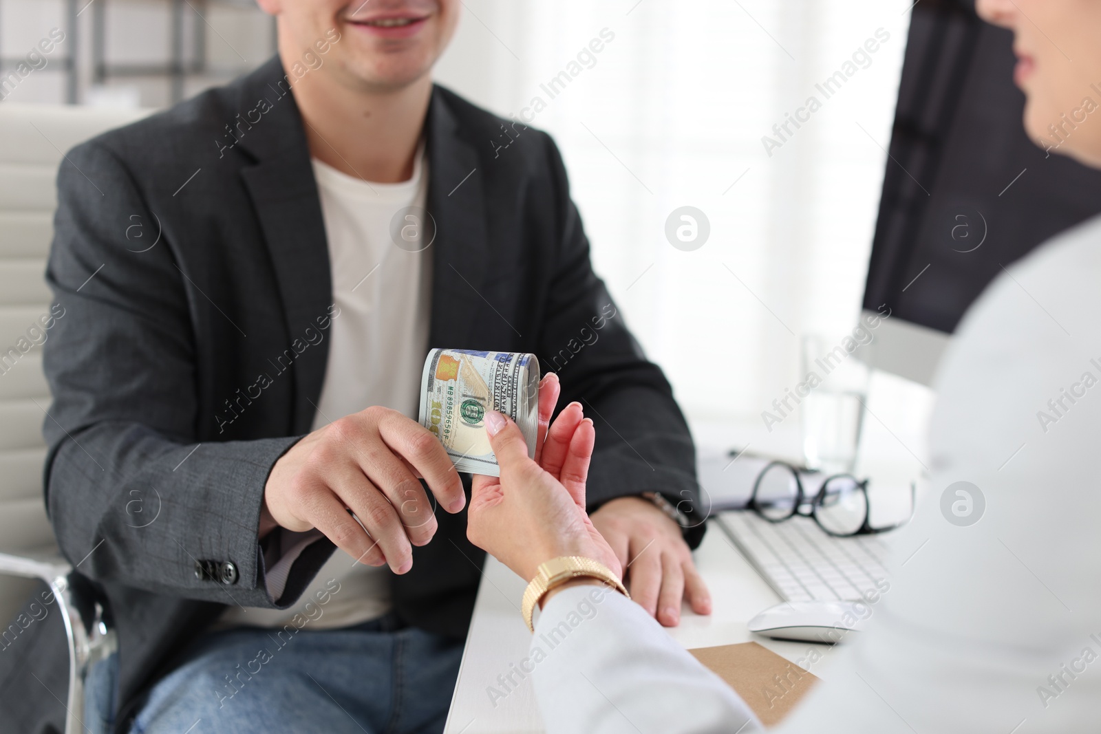 Bonus. Boss giving money to employee in office, closeup Photo of Bonus. Boss giving money to employee in office, closeup