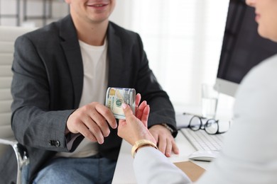 Photo of Bonus. Boss giving money to employee in office, closeup