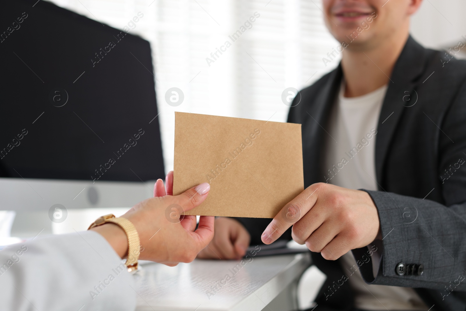 Money bonus. Boss giving envelope to employee in office, closeup Photo of Money bonus. Boss giving envelope to employee in office, closeup