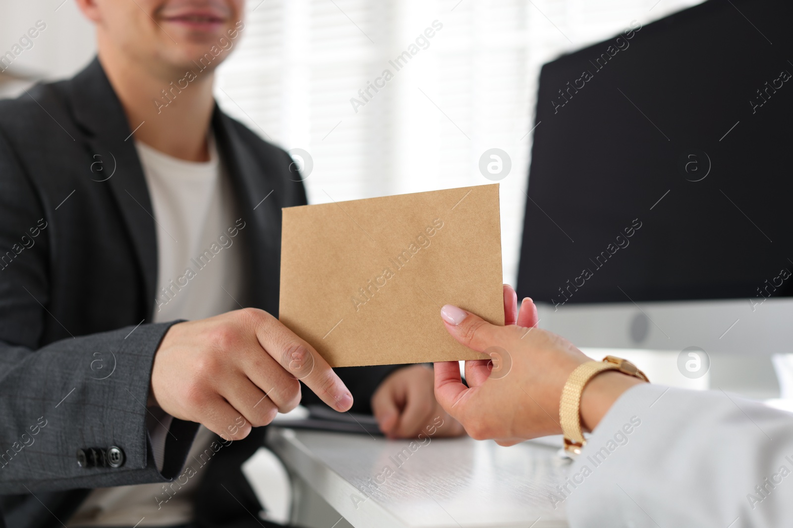 Money bonus. Boss giving envelope to employee in office, closeup Photo of Money bonus. Boss giving envelope to employee in office, closeup