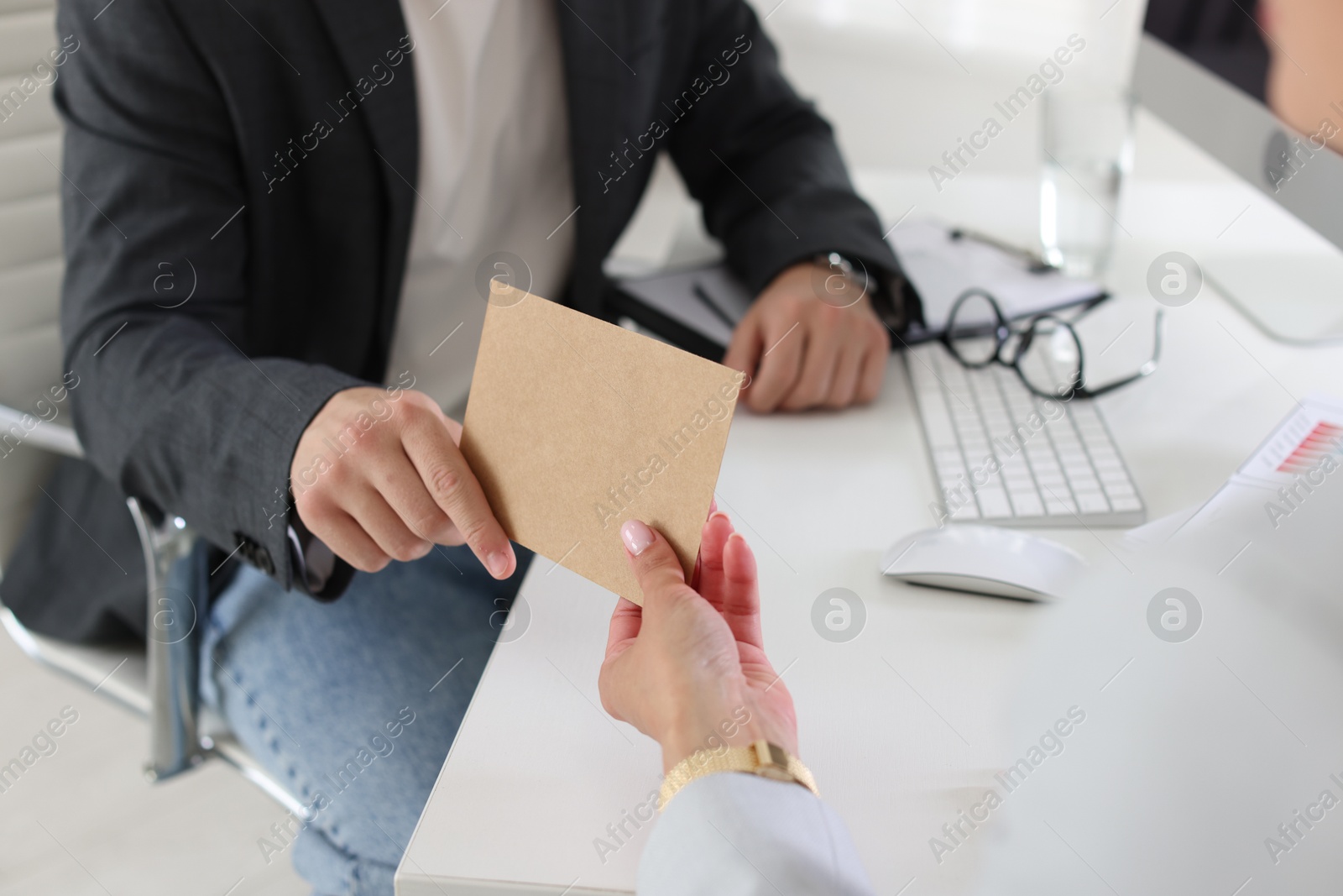 Money bonus. Boss giving envelope to employee in office, closeup Photo of Money bonus. Boss giving envelope to employee in office, closeup