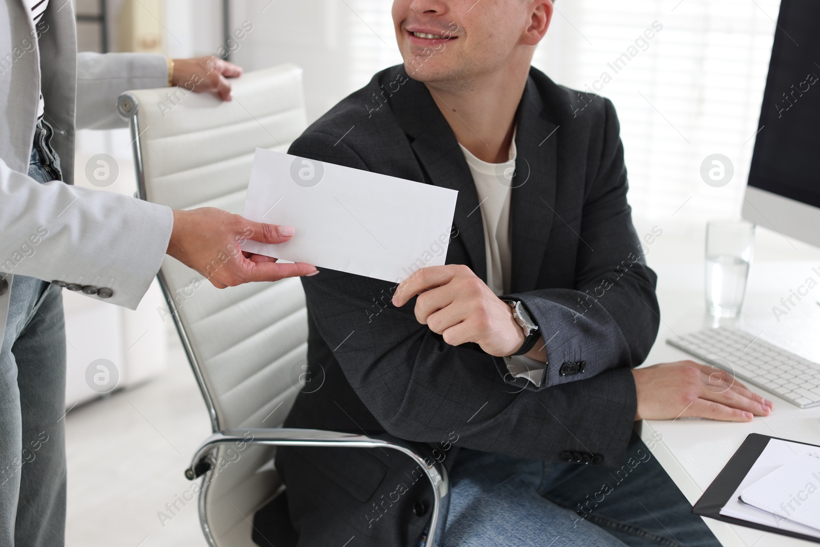 Money bonus. Employee receiving envelope from boss in office, closeup Photo of Money bonus. Employee receiving envelope from boss in office, closeup