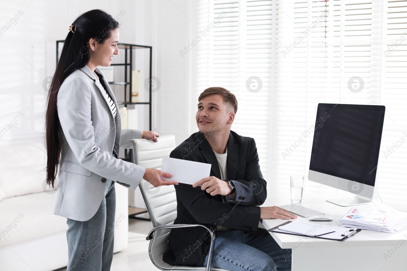 Money bonus. Employee receiving envelope from boss in office Photo of Money bonus. Employee receiving envelope from boss in office