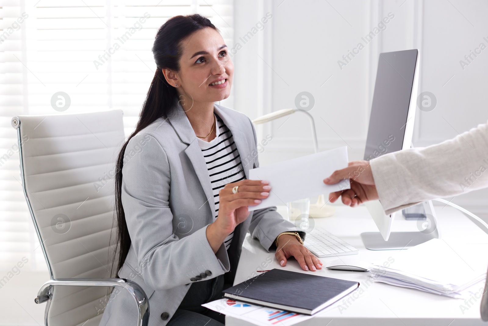 Money bonus. Employee receiving envelope from boss in office Photo of Money bonus. Employee receiving envelope from boss in office