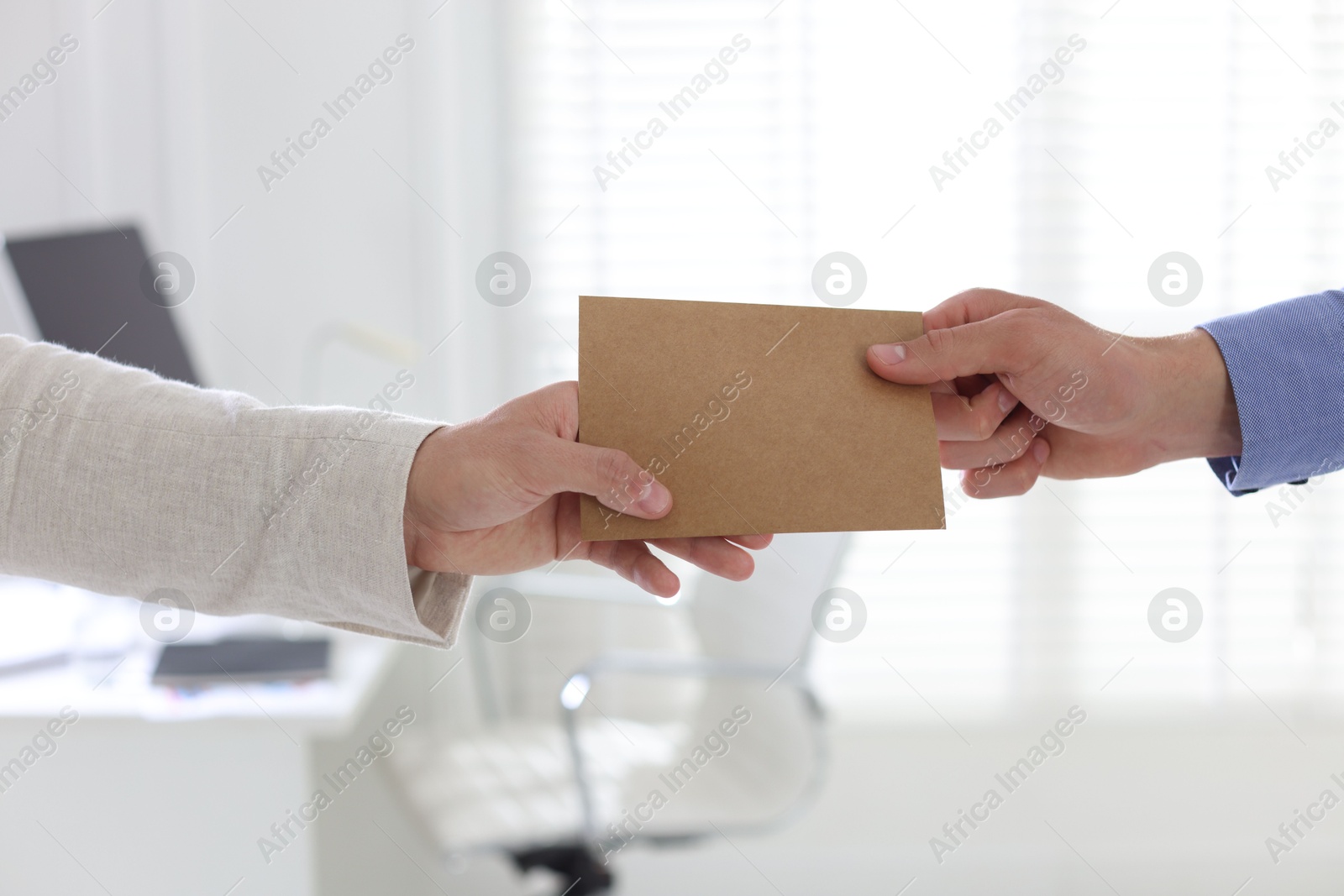 Money bonus. Employee receiving envelope from boss in office, closeup Photo of Money bonus. Employee receiving envelope from boss in office, closeup