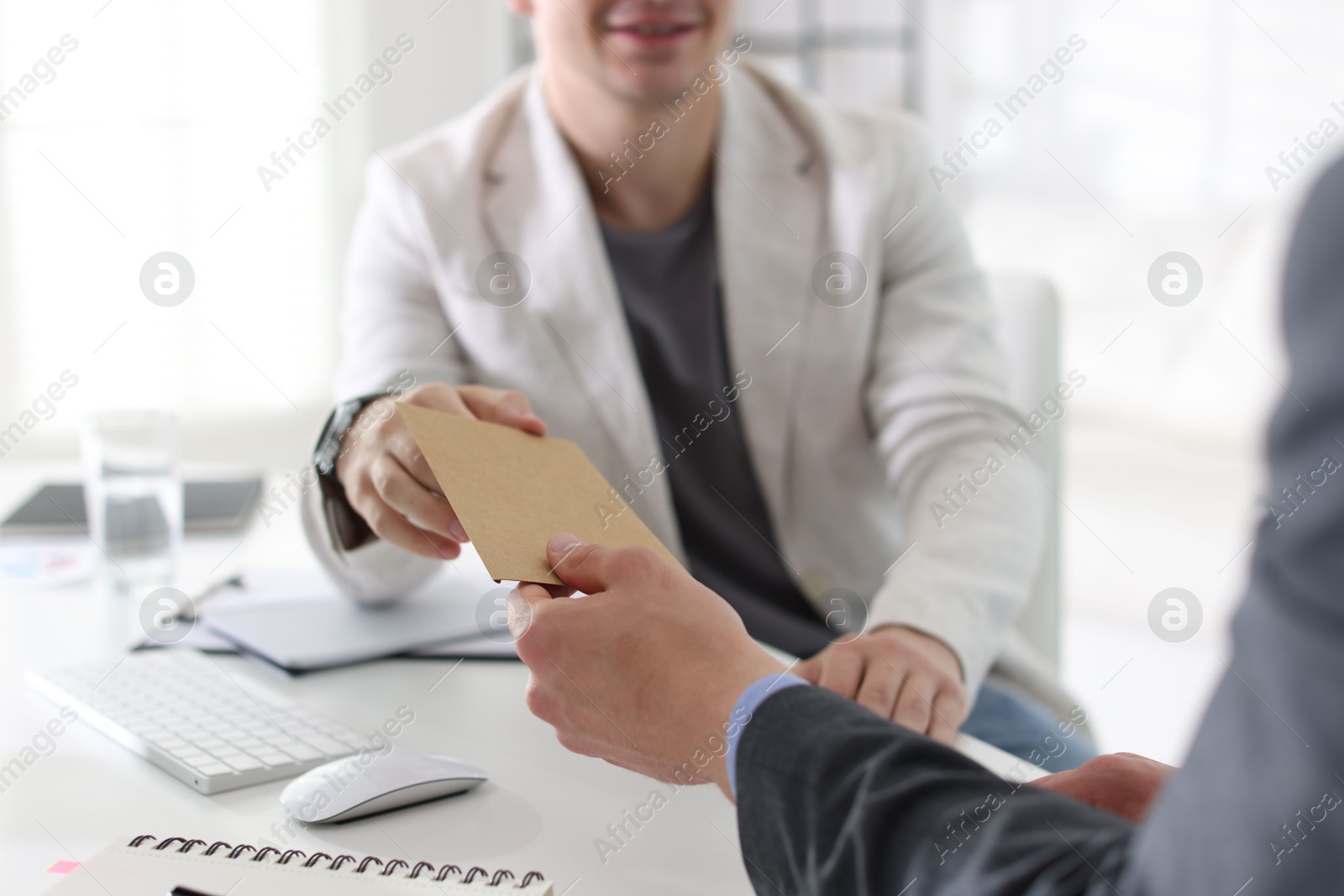 Money bonus. Employee receiving envelope from boss in office, closeup Photo of Money bonus. Employee receiving envelope from boss in office, closeup