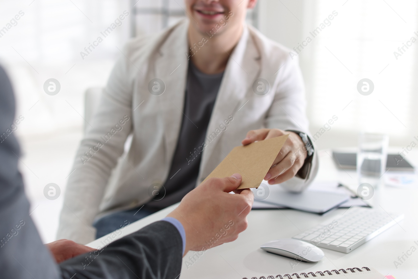 Money bonus. Employee receiving envelope from boss in office, closeup Photo of Money bonus. Employee receiving envelope from boss in office, closeup