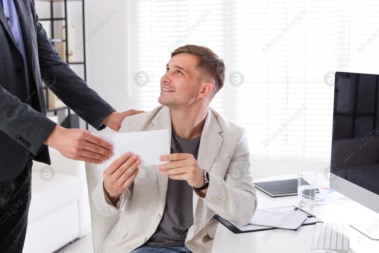 Money bonus. Employee receiving envelope from boss in office Photo of Money bonus. Employee receiving envelope from boss in office