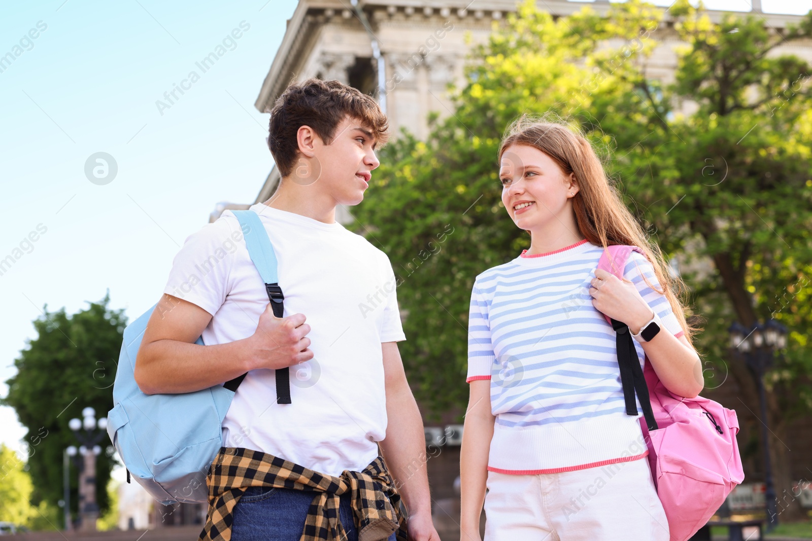 Teenage girl and boy walking together outdoors Photo of Teenage girl and boy walking together outdoors