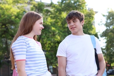 Photo of Teenage girl and boy walking together outdoors