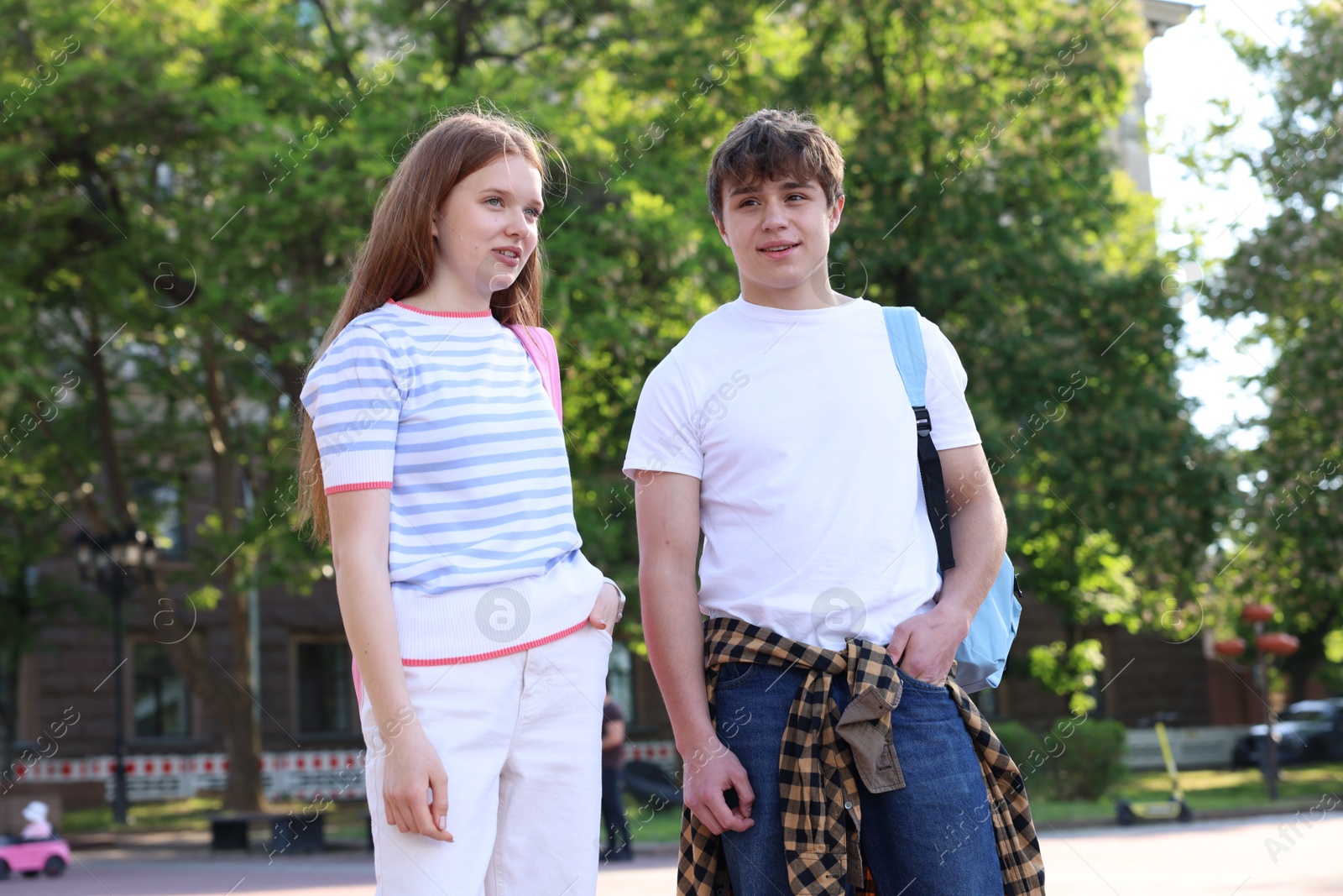 Teenage girl and boy walking together outdoors Photo of Teenage girl and boy walking together outdoors